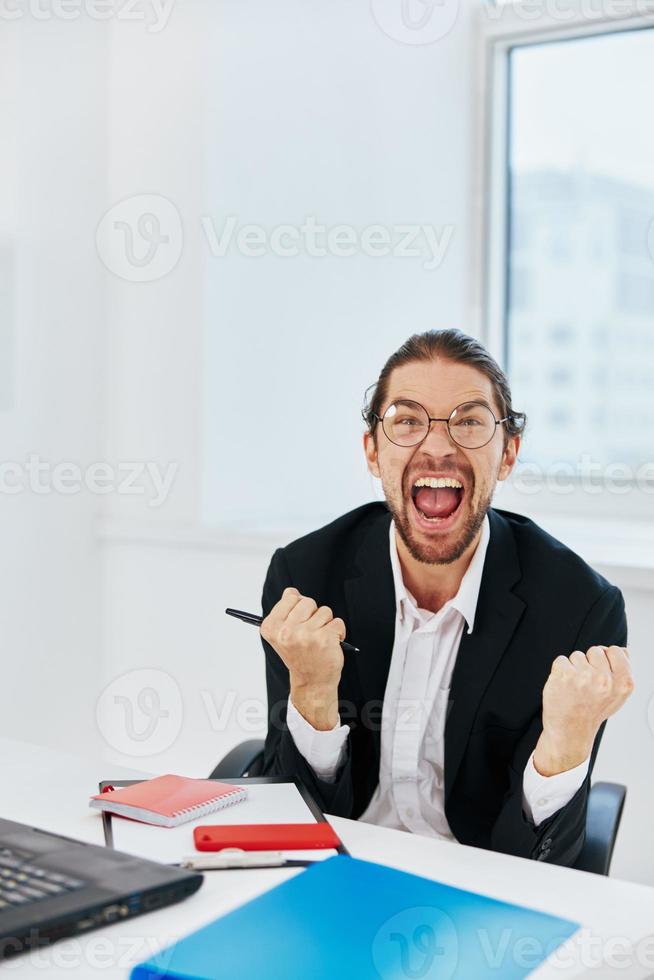 Mens in een pak werk in de kantoor in voorkant van een laptop technologieën foto