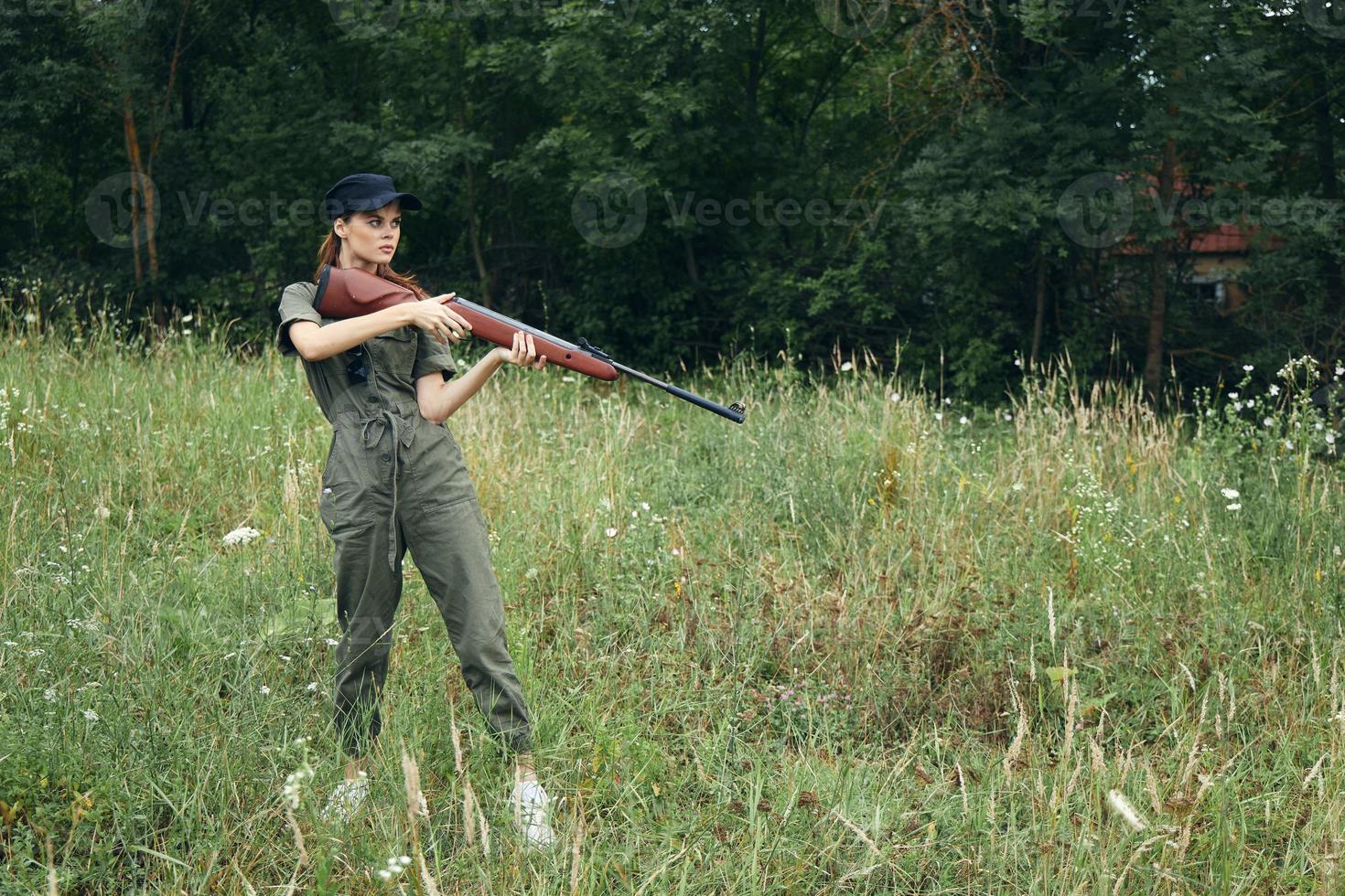 leger vrouw met een geweer in hand- jacht- reizen levensstijl groen bladeren foto