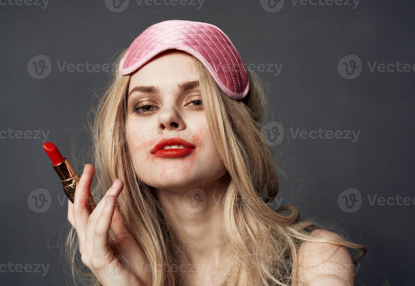 sexy blond vrouw met rood lippenstift emoties en roze masker Aan haar gezicht foto