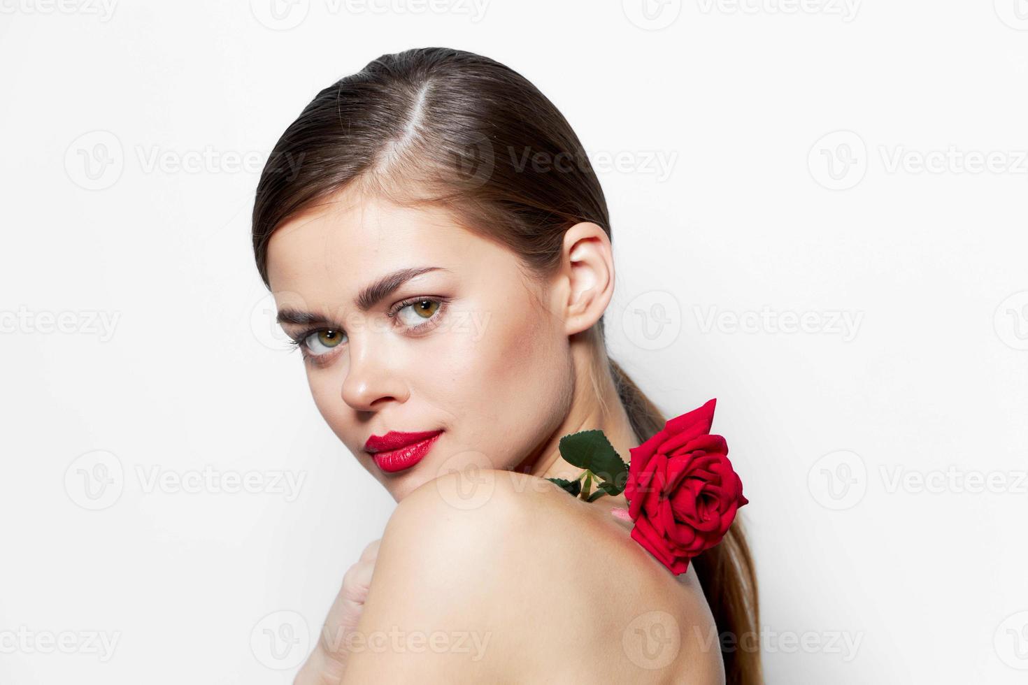 mooi vrouw roos bloem Aan de schouders Doorzichtig huid rood lippen foto