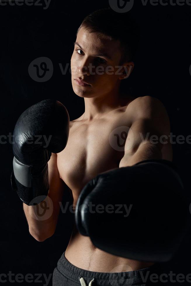 atleet in boksen handschoenen Aan zwart achtergrond portret bijgesneden visie model- detailopname foto