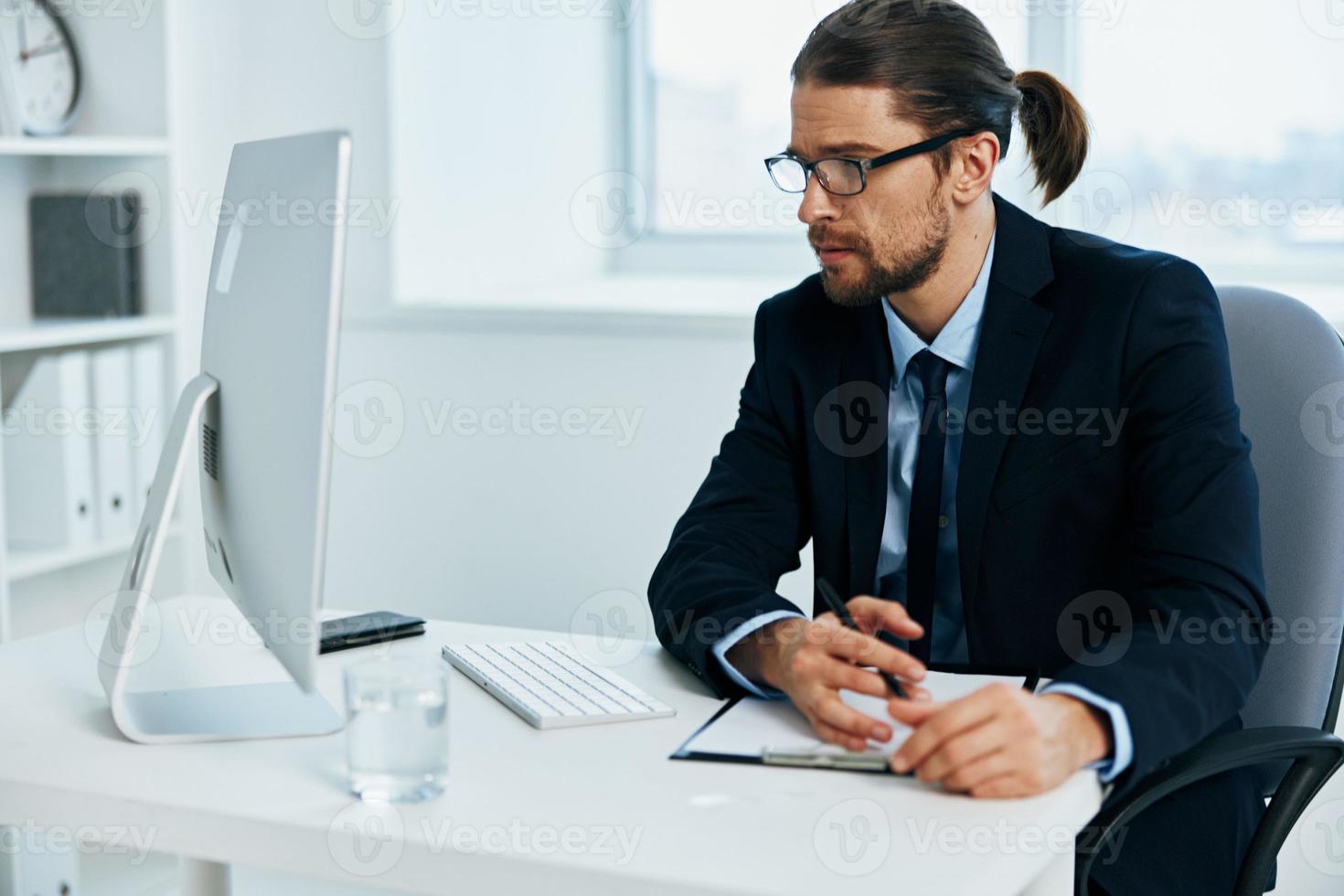 kantoor arbeider zittend Bij een bureau in voorkant van een computer levensstijl foto