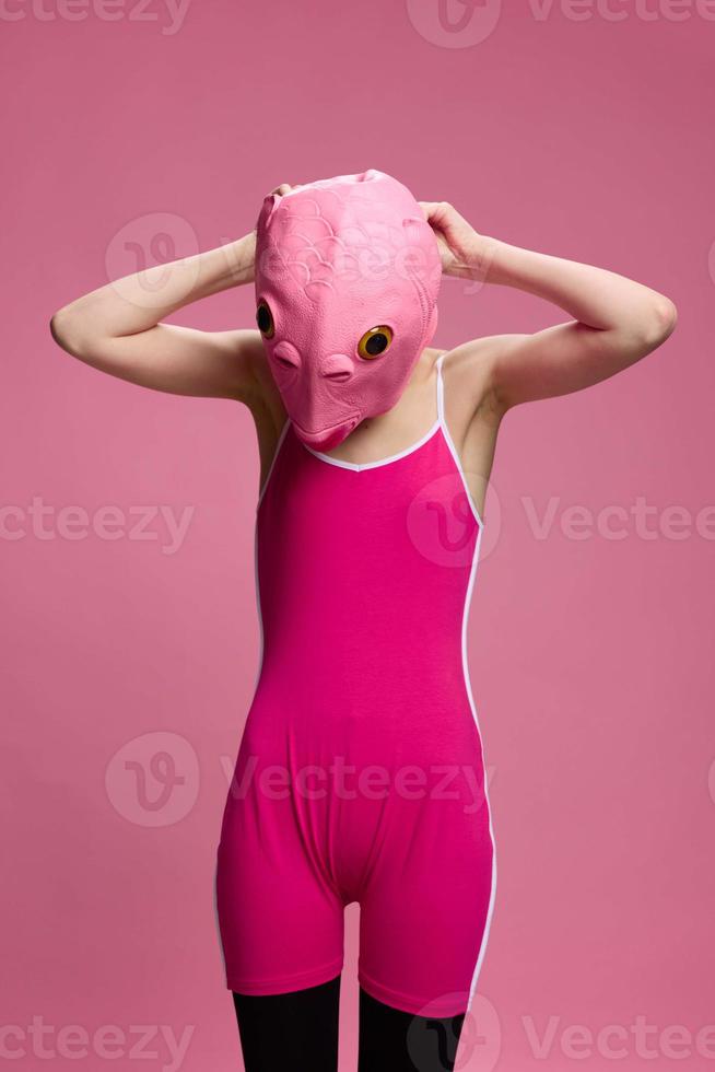 heel vreemd vrouw in een roze siliconen vis masker voor halloween, gek beeld in roze kleren foto