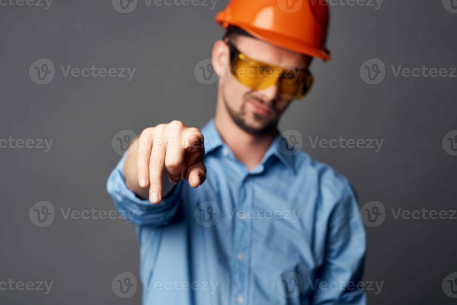 Mens in bouw uniform blauw overhemd gebaar handen emoties werk foto
