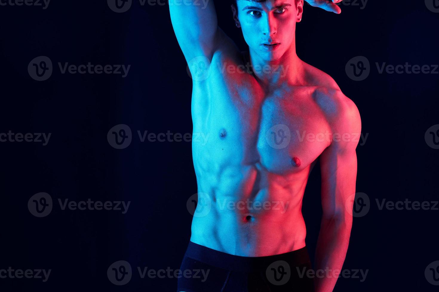 mannetje atleet met neon huid kleur Aan geïsoleerd achtergrond houdt hand- achter hoofd bijgesneden visie foto