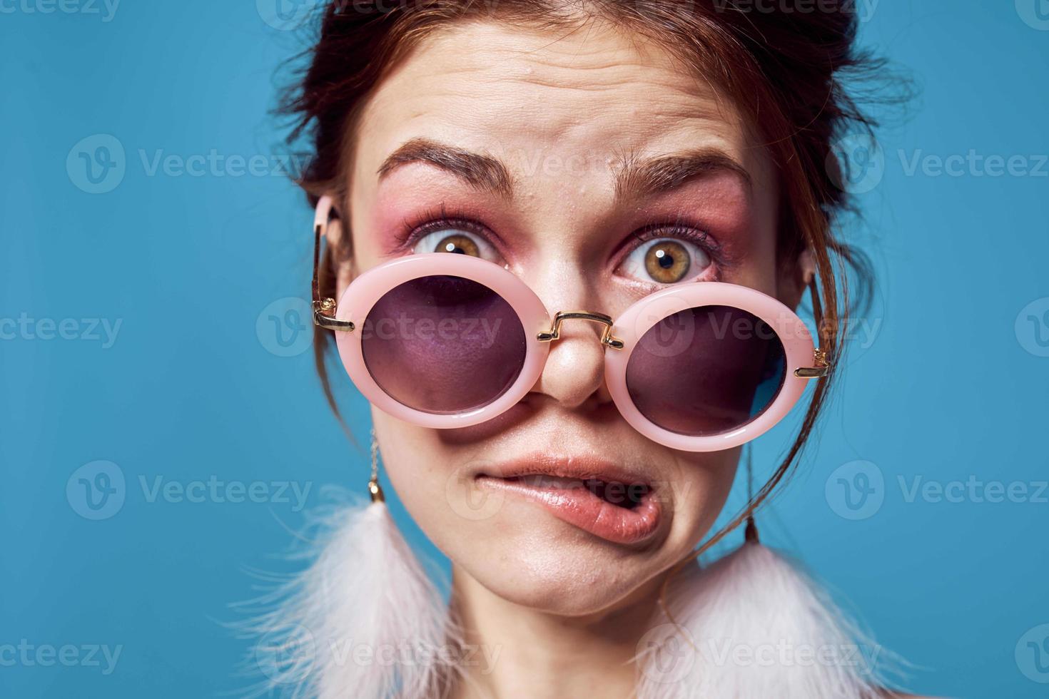 emotioneel vrouw vervelend zonnebril pluizig oorbellen sieraden detailopname blauw achtergrond foto