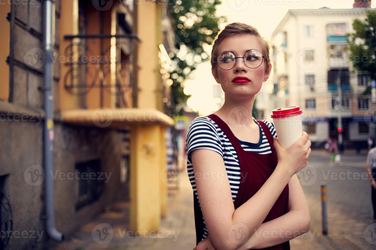 mooi vrouw met kort haren bril buitenshuis een kop van drinken foto