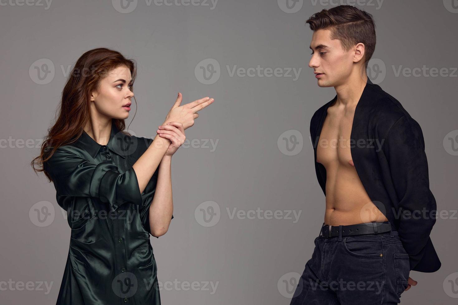 vrouw shows twee vingers Aan een Mens grijs achtergrond bijgesneden visie foto