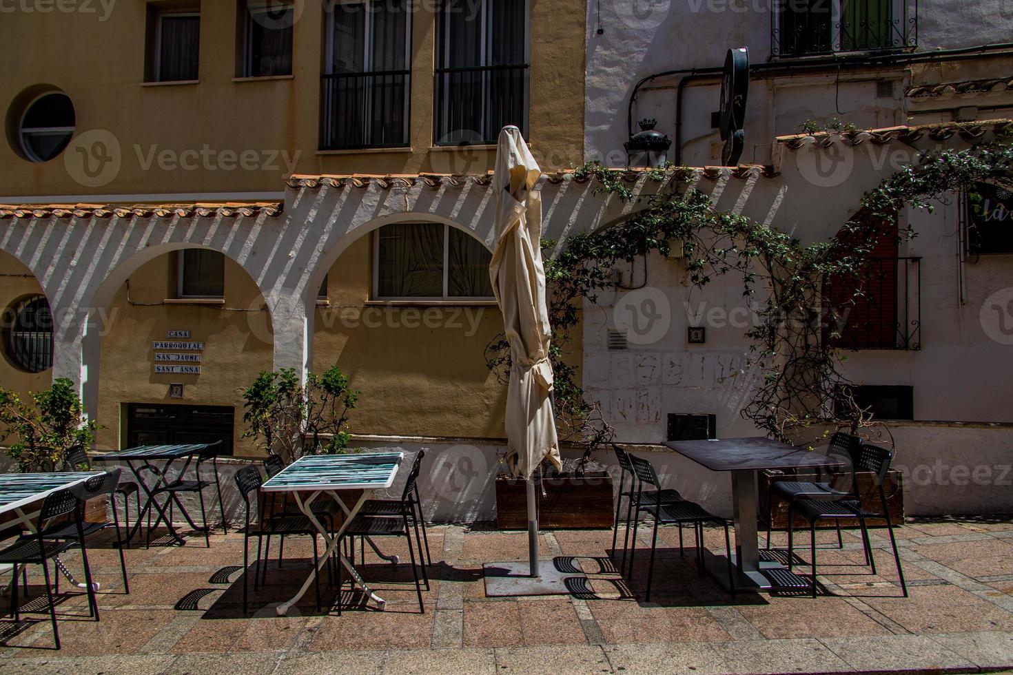 l stedelijk landschap van een Spaans straat in benidorm met een cafe en tafels Aan de trottoir zonder mensen foto