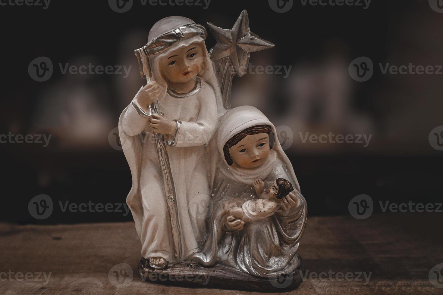 keramisch beeldjes van de moeder van god Joseph en baby Jezus voor de geboorte tafereel Aan een donker bruin achtergrond foto