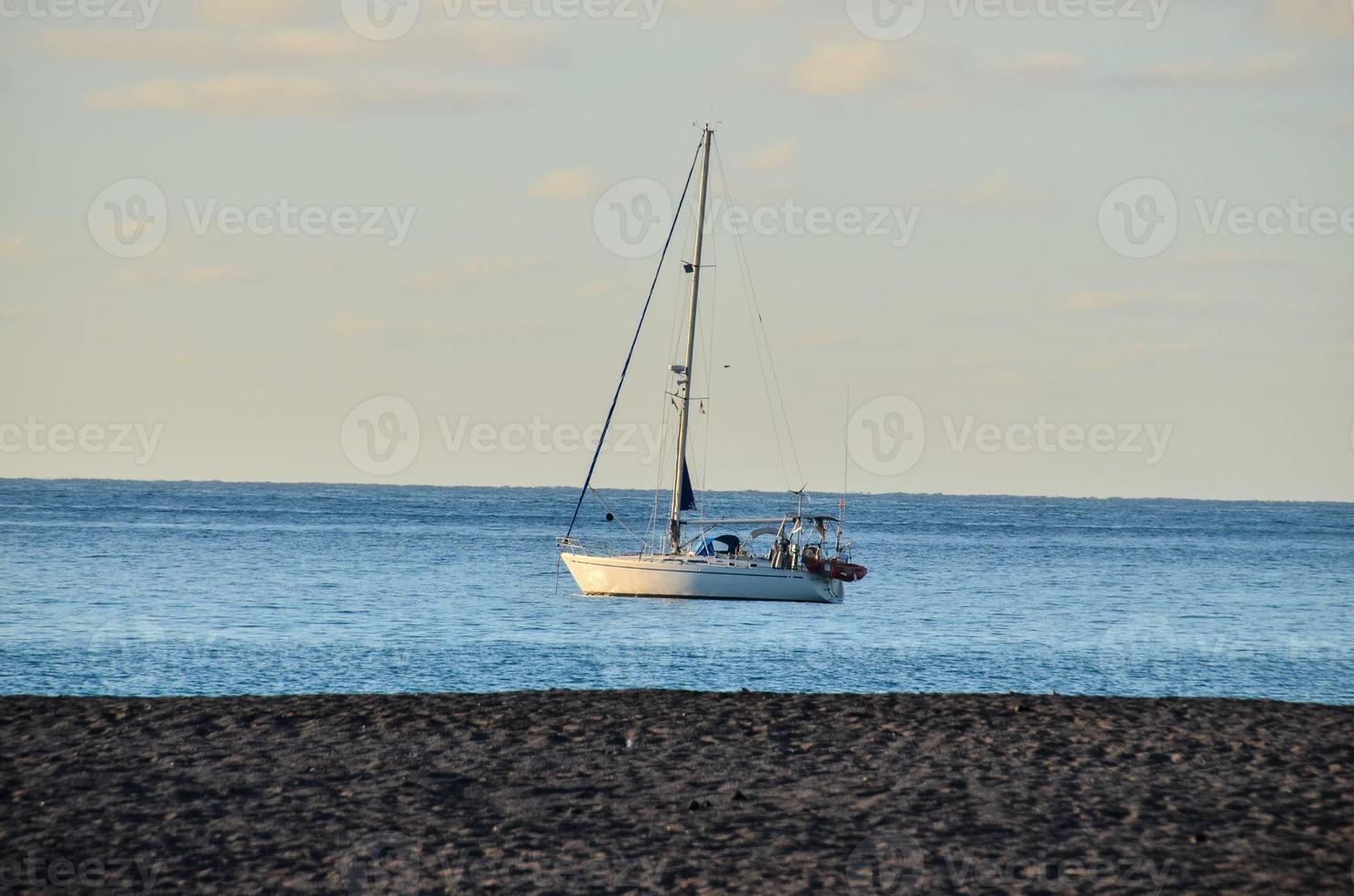 het zeilen jacht door de kust foto