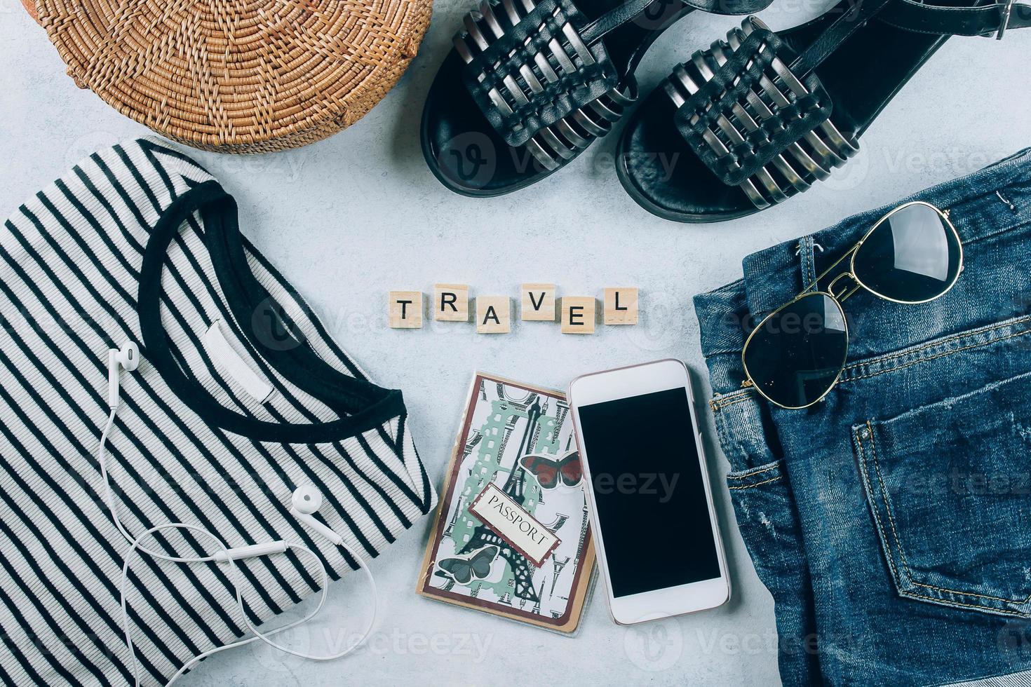 reizen vlak leggen. voorjaar en zomer vrouwen kleding en accessoires. gestreept t-shirt, zomer sandalen, blauw denim korte broek, modieus biologisch rotan tas. vakantie, reizen concept. top visie foto