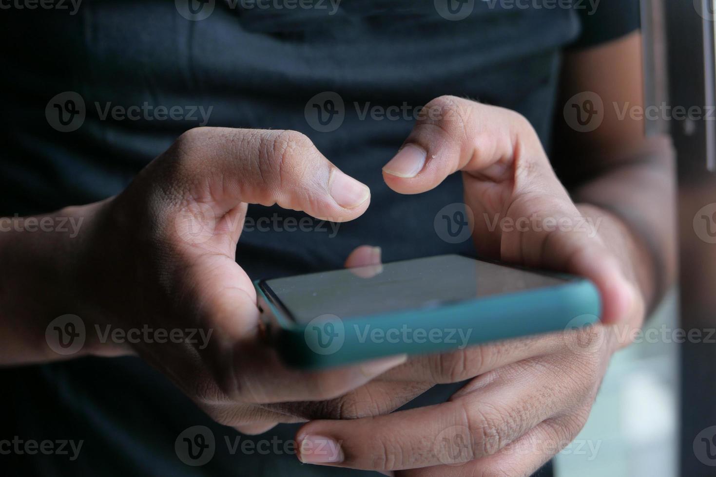 close-up van de hand van de jonge man met behulp van slimme telefoon foto