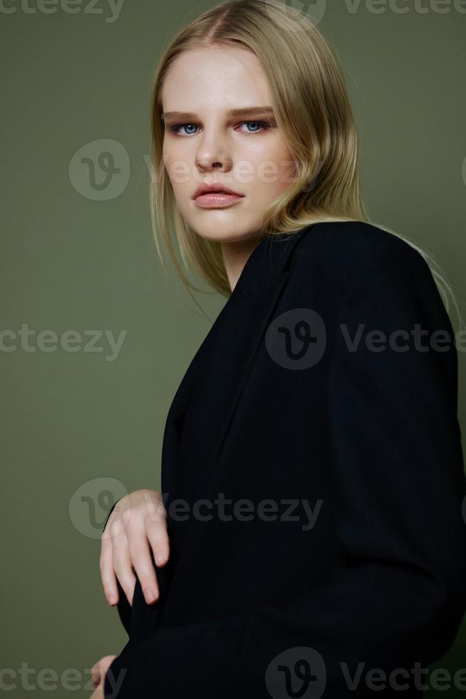 portret van een verbijsterend elegant meisje in een zwart pak poseren professioneel Aan een groen achtergrond in de studio. de concept van reclame voor ontwerper merken foto