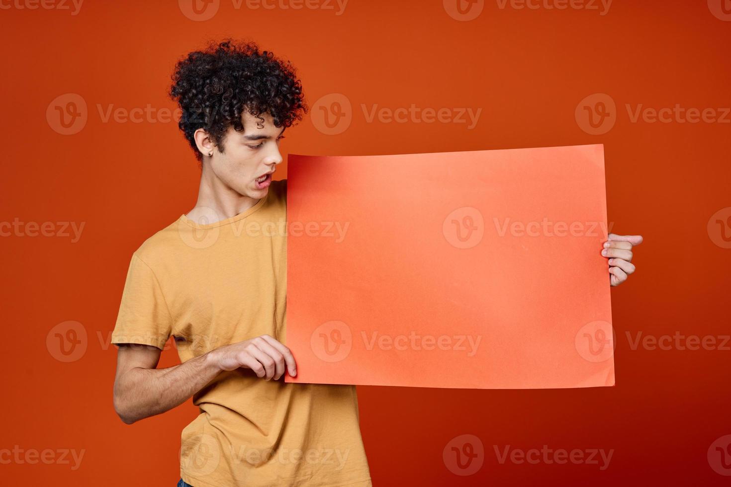 vent met gekruld haar- Holding een rood kopiëren ruimte poster foto