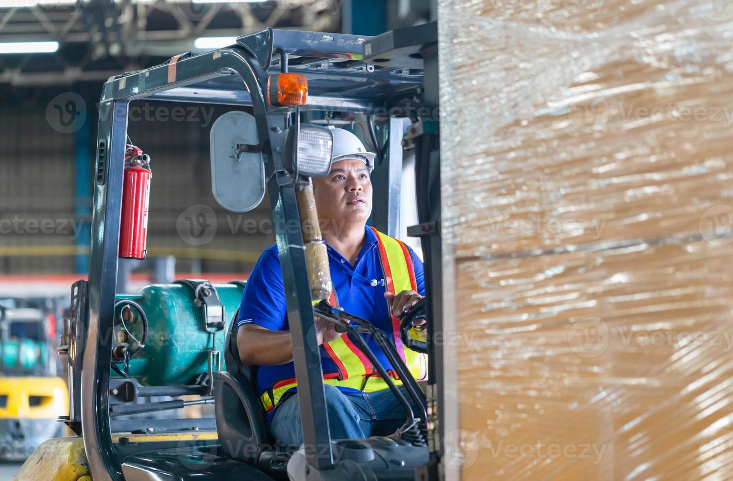 arbeider op vorkheftruck, handarbeiders werken in magazijn, arbeider chauffeur bij magazijn heftrucklader werkt foto