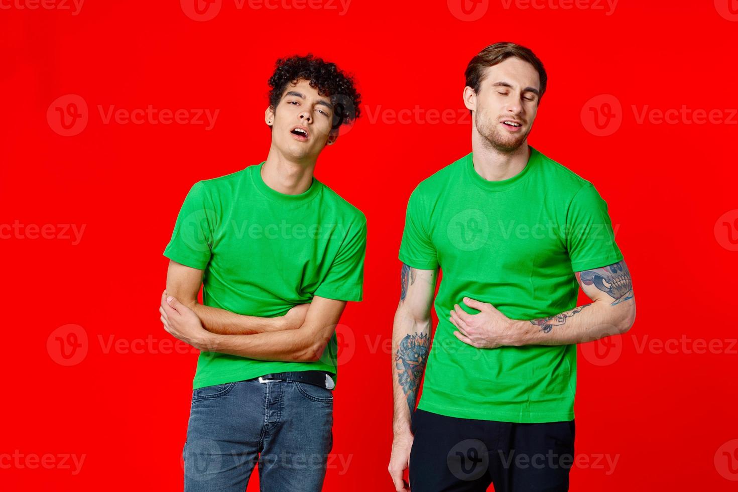 twee vrienden in groen t-shirts houden hun buik emoties foto