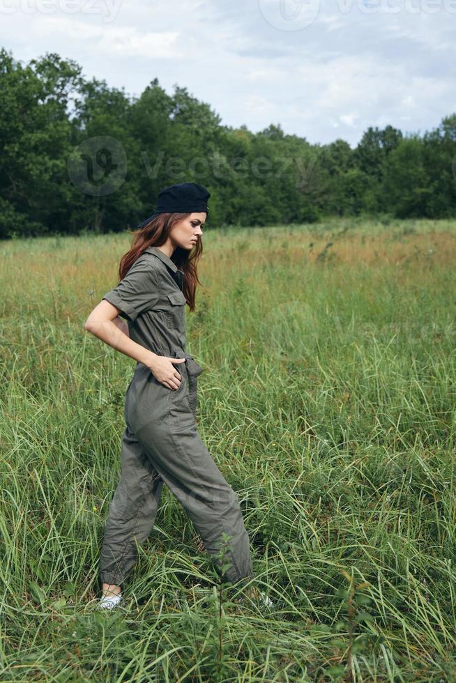 vrouw in de veld- in groen jumpsuit wandelen zwart pet vers lucht foto