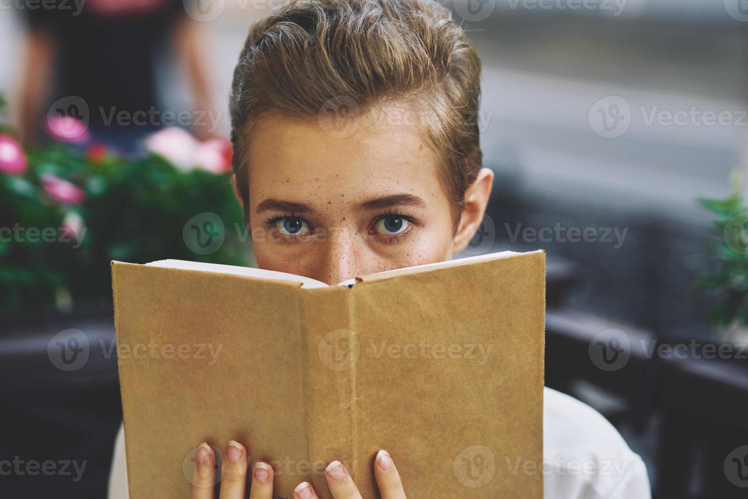 leerling met een boek in zijn handen buitenshuis rust uit pret wandelen in de omgeving van stad- onderwijs foto