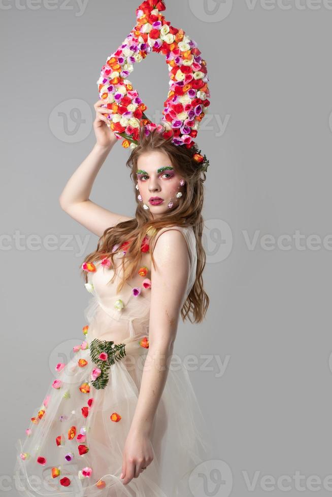 sprookje meisje model- met bloemen hoorns Aan een grijs achtergrond. kwaadaardig. voorjaar meisje. vrouw bloem. bloemen verzinnen. zomer vrouw. foto