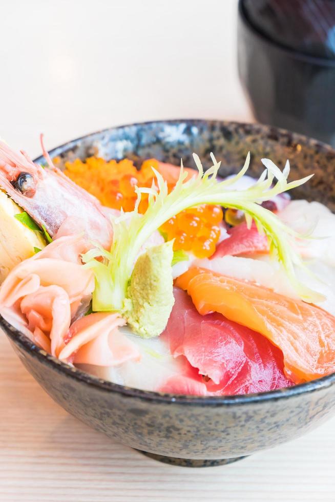 Japanse rijstkom met sashimi zeevruchten bovenop foto
