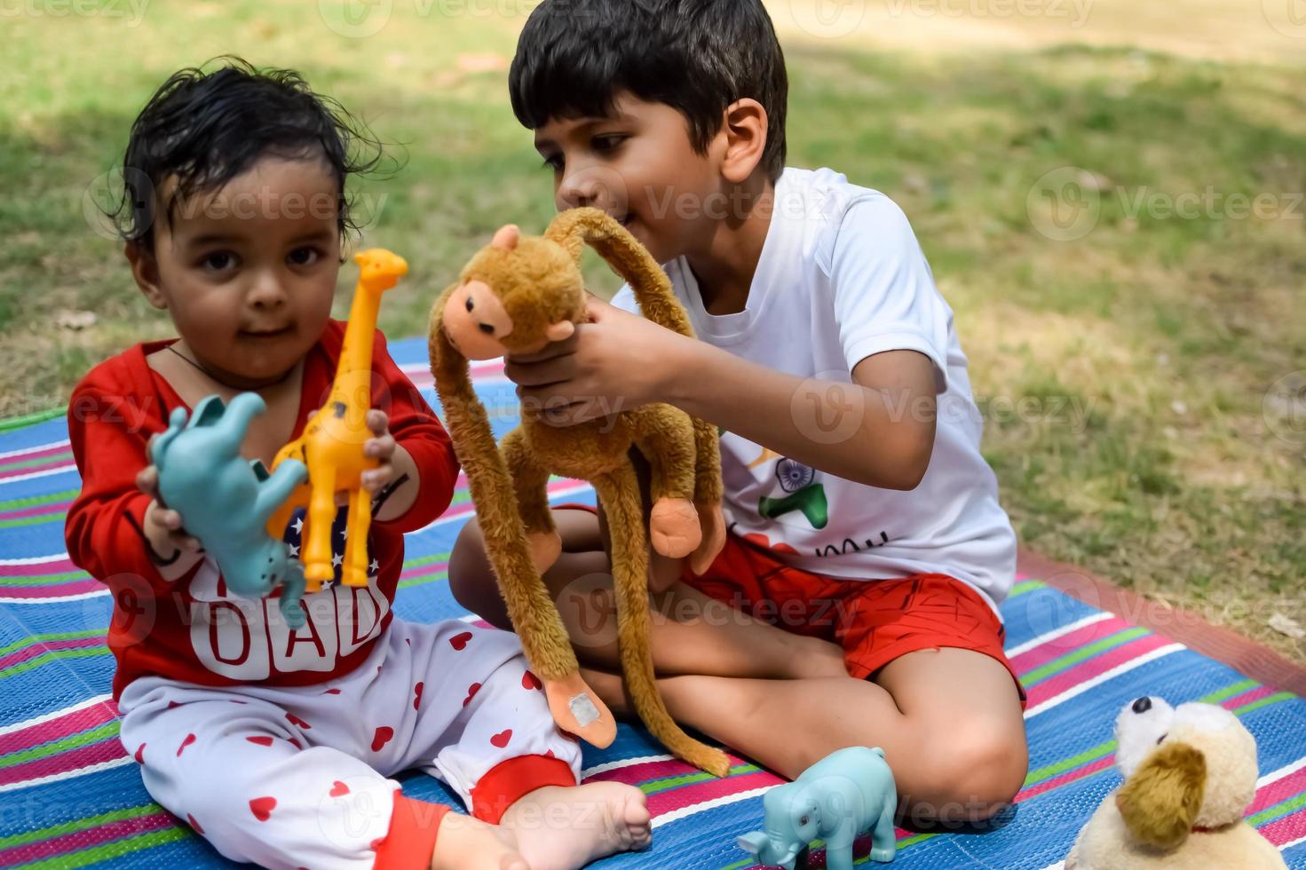 twee gelukkig jongens in maatschappij park, gelukkig Aziatisch broers wie zijn glimlachen gelukkig samen. broers Speel buitenshuis in zomer, het beste vrienden. kleuter baby jongen spelen met zijn gelukkig broer in de tuin foto