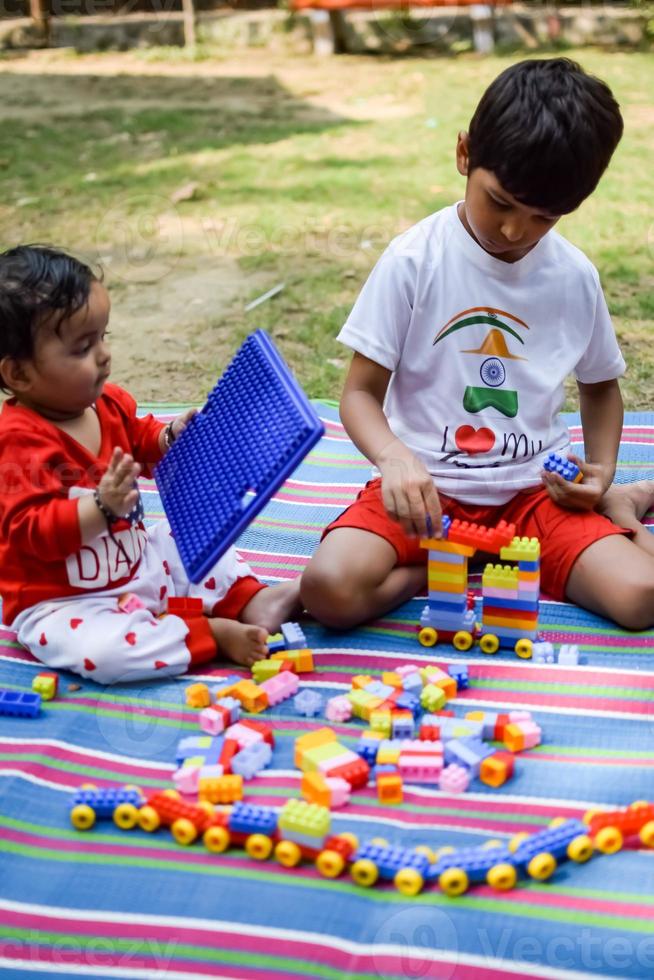 twee gelukkig jongens in maatschappij park, gelukkig Aziatisch broers wie zijn glimlachen gelukkig samen. broers Speel buitenshuis in zomer, het beste vrienden. kleuter baby jongen spelen met zijn gelukkig broer in de tuin foto