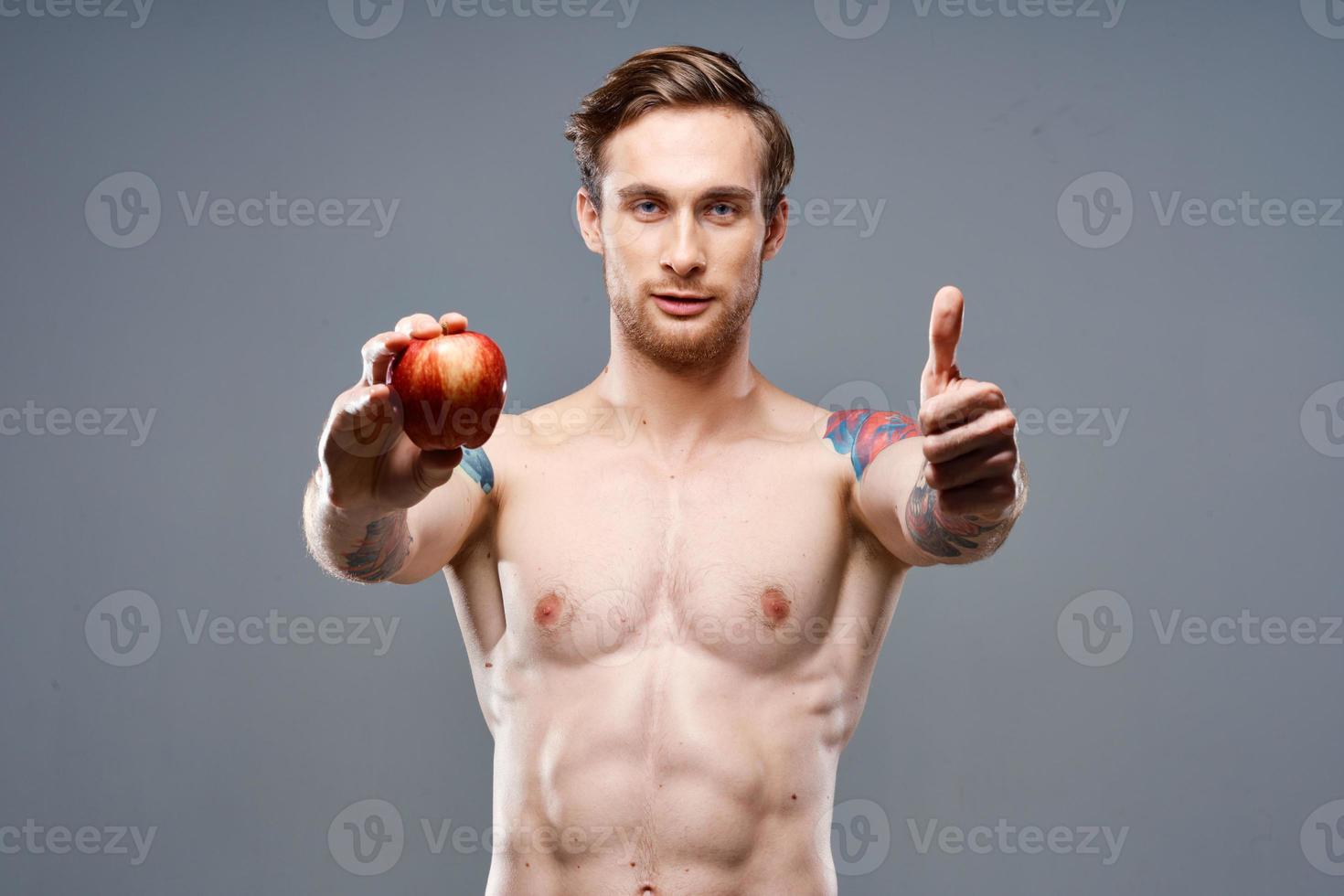 atletisch vent met een gemotiveerd omhoog torso gezond levensstijl voeding vitamines rood appel foto