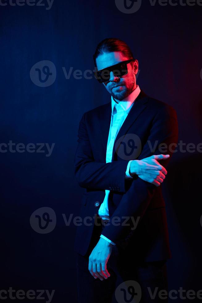 portret van een Mens modern stijl pak mode zonnebril donker achtergrond foto