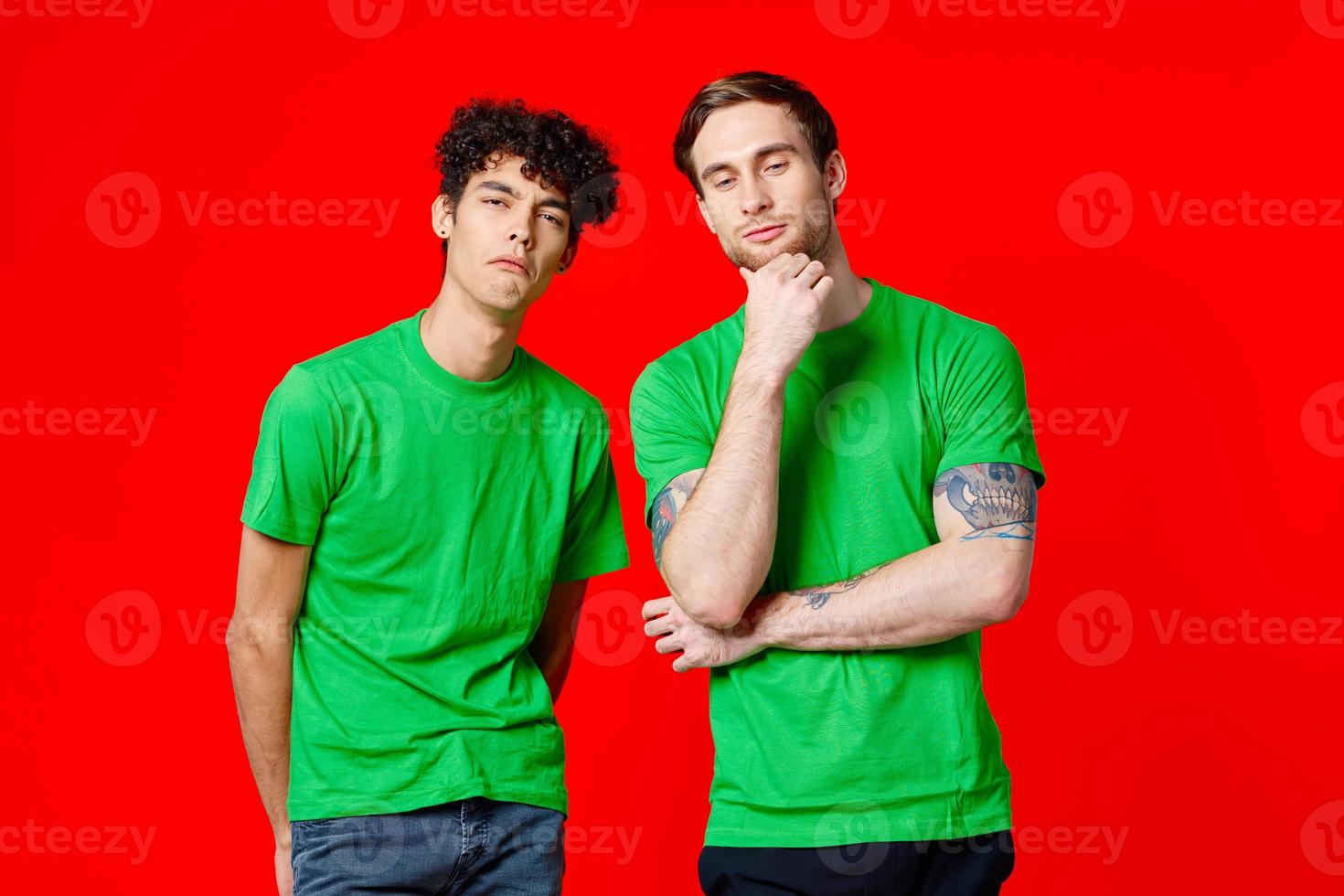 twee vrolijk vrienden in groen t-shirts zijn staand De volgende naar elk andere emoties geïsoleerd achtergrond foto