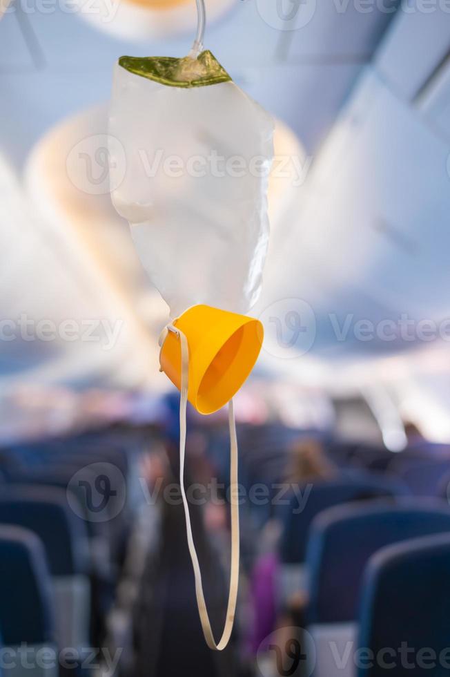 zuurstofmasker valt uit het plafondcompartiment in het vliegtuig foto