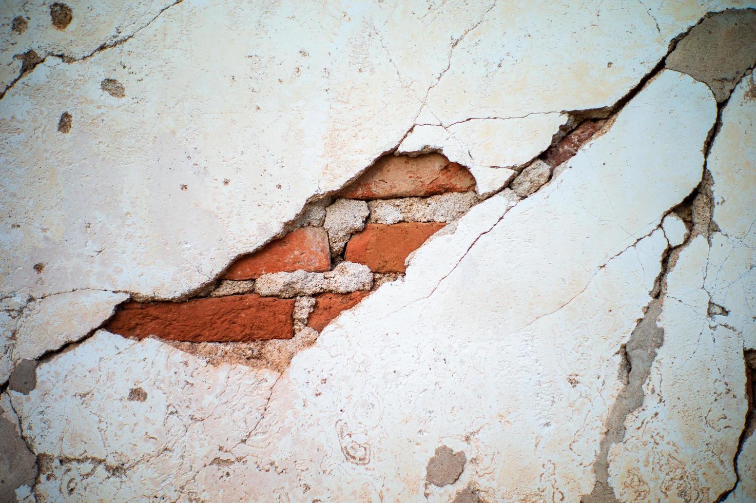 achtergrond en textuur van gebroken cementmuur met binnen metselaars foto