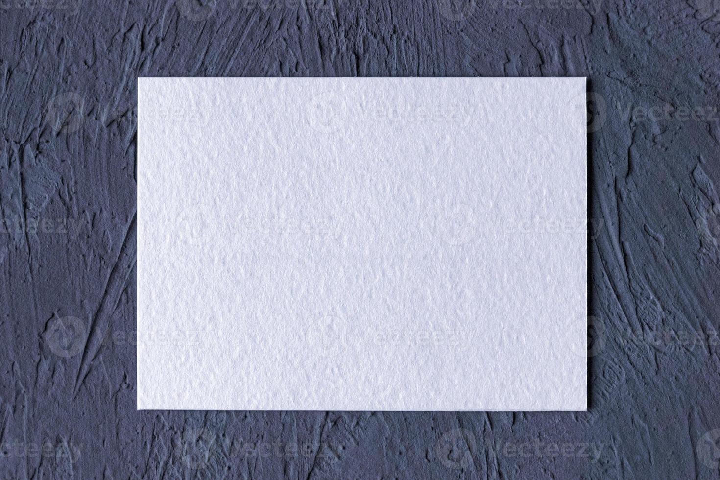 wit getextureerde papier kaart Aan donker grijs solide achtergrond foto