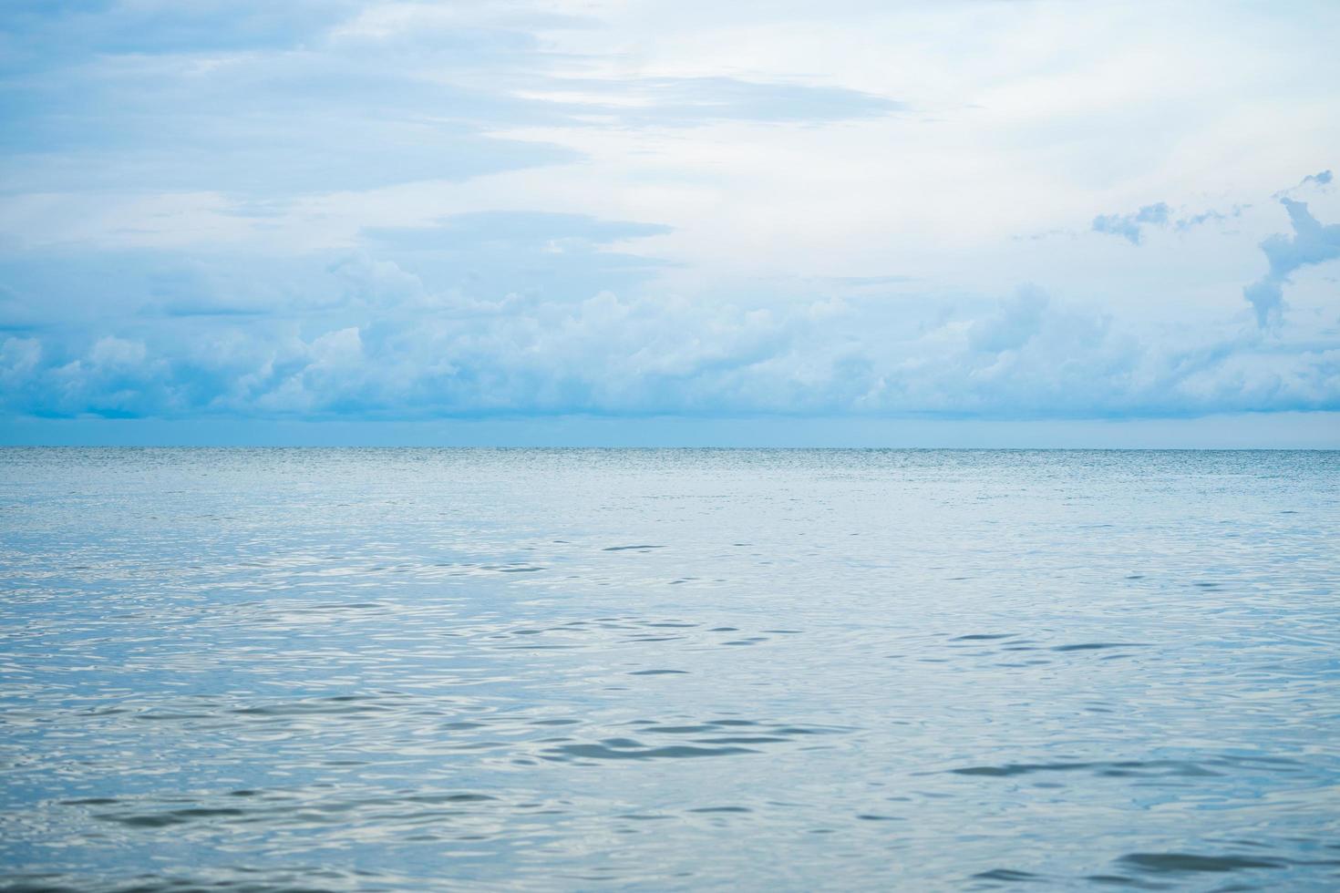 landschaps horizontale horizon van oceaan en kalme zee met bewolkte hemel op achtergrond foto