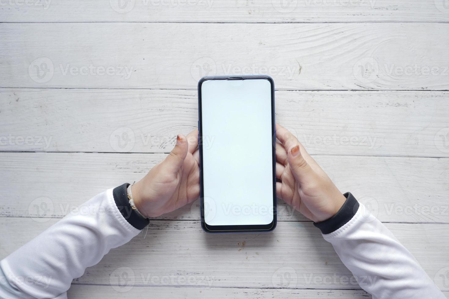 kind hand- Holding een slim telefoon met leeg ruimte foto