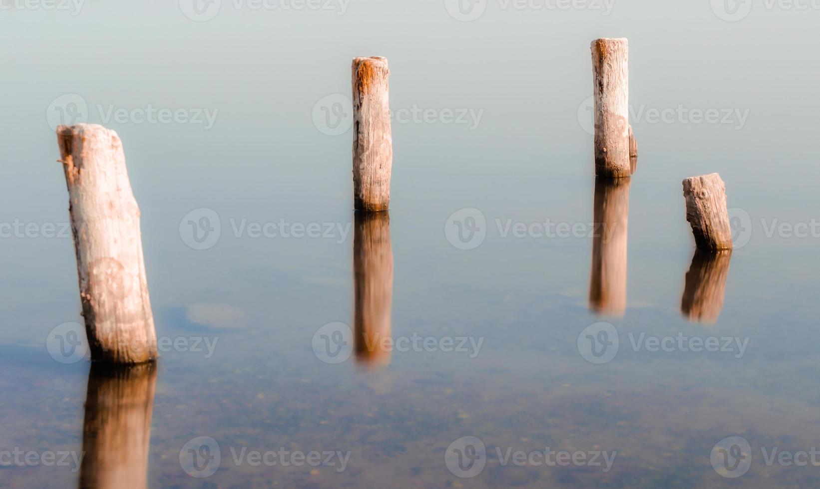 houten kolommen in kalm water foto