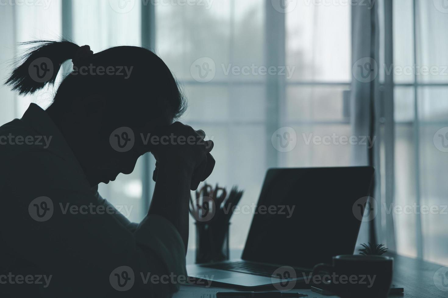 spanning bedrijf vrouw persoon van moeilijk werk, depressie in kantoor. moe en angstig werknemer vrouw met ongelukkig Bij probleem functie. jong zakenvrouw zittend verdrietig voorkant van laptop computer Aan bureau. foto