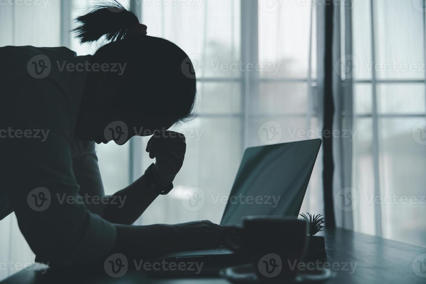 spanning bedrijf vrouw persoon van moeilijk werk, depressie in kantoor. moe en angstig werknemer vrouw met ongelukkig Bij probleem functie. jong zakenvrouw zittend verdrietig voorkant van laptop computer Aan bureau. foto