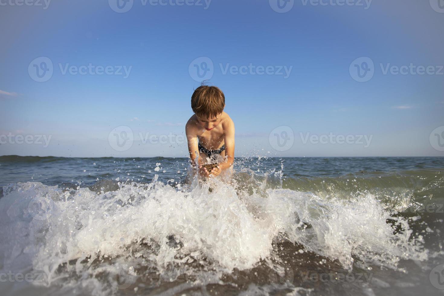 kind Aan vakantie. een jongen Bij de zee Toneelstukken met de golven. foto