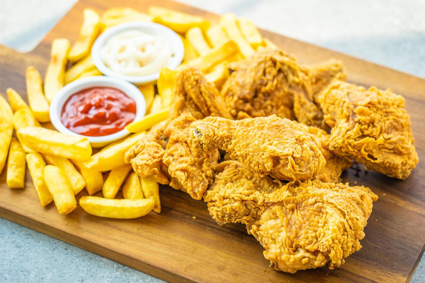 gebakken kippenvleugels met frietjes en tomaat of ketchup en mayonaisesaus foto