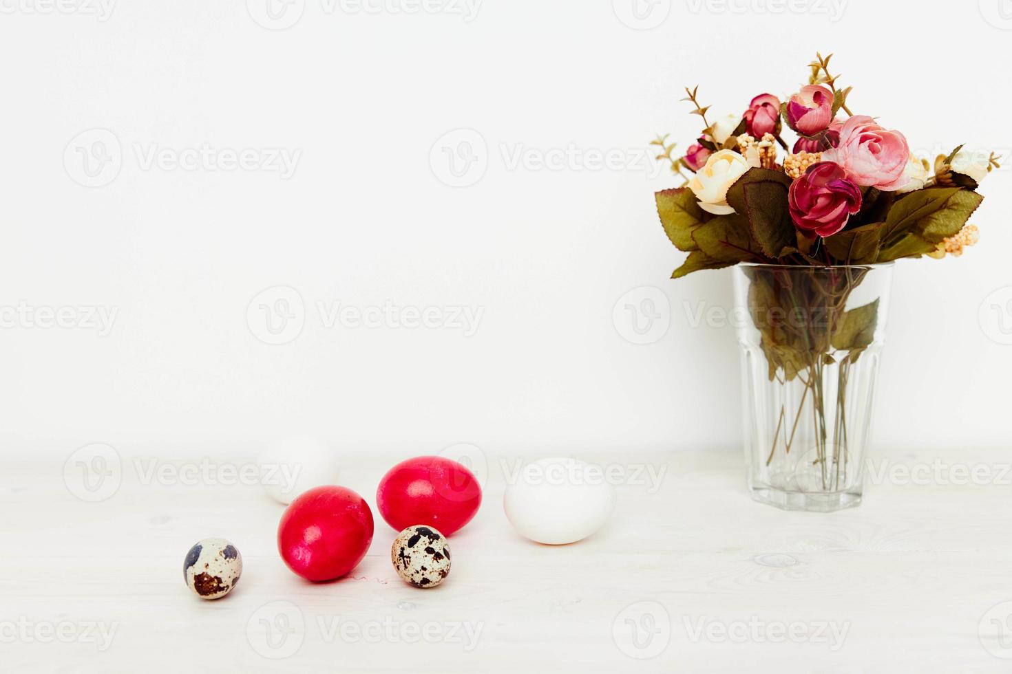 vakantie van licht Pasen en geschilderd eieren Aan de tafel een boeket van bloemen in een vaas foto