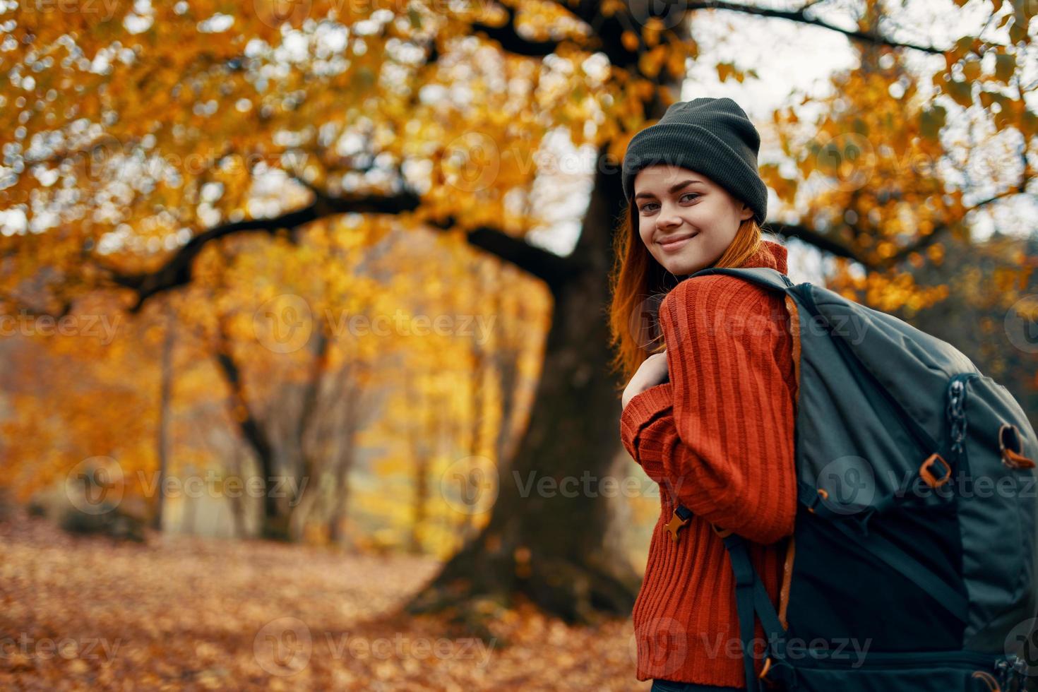 gelukkig vrouw met rugzak wandelen in park in natuur in herfst bijgesneden visie foto