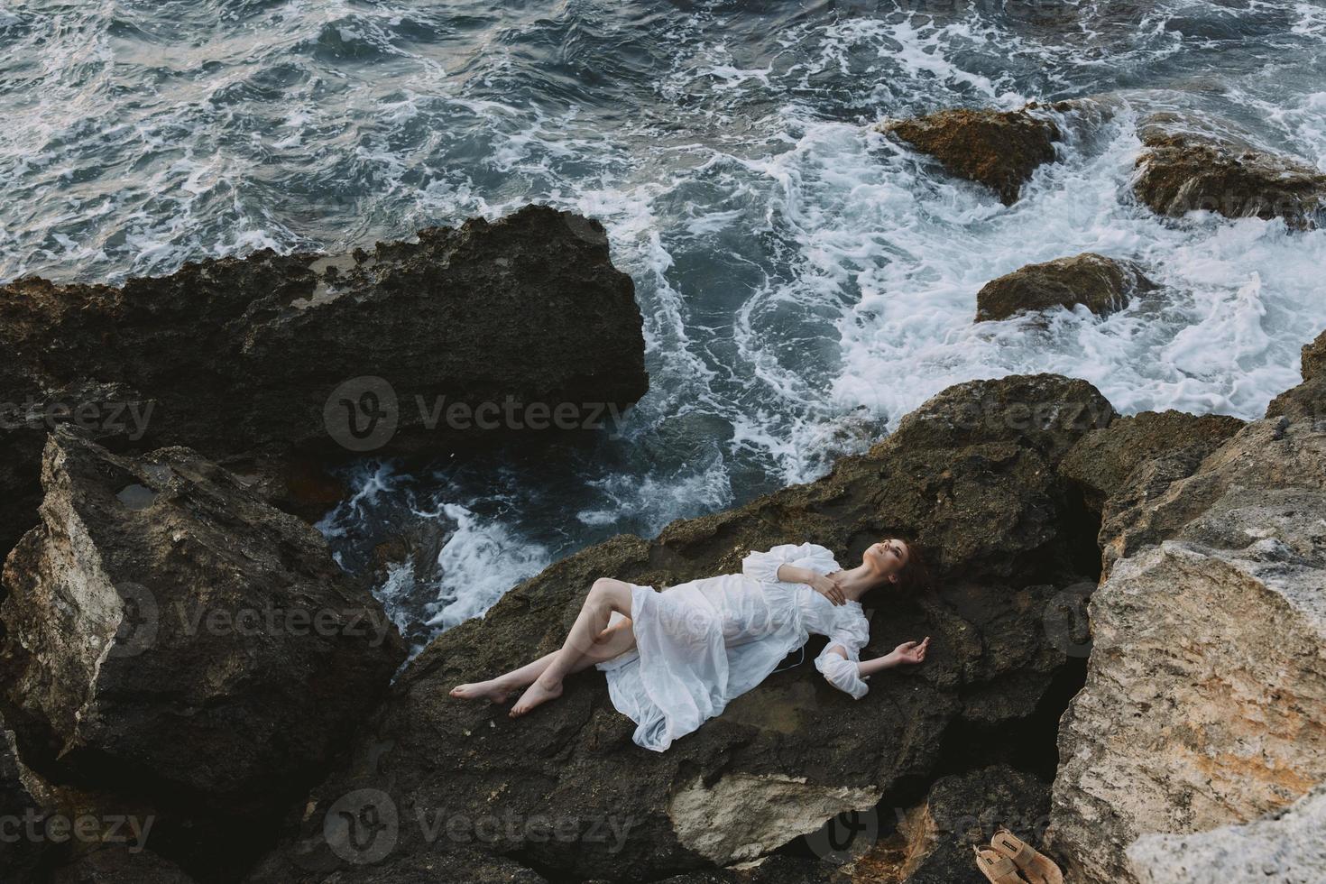 mooi vrouw in wit bruiloft jurk Aan zee kust nat haar- natuur landschap foto