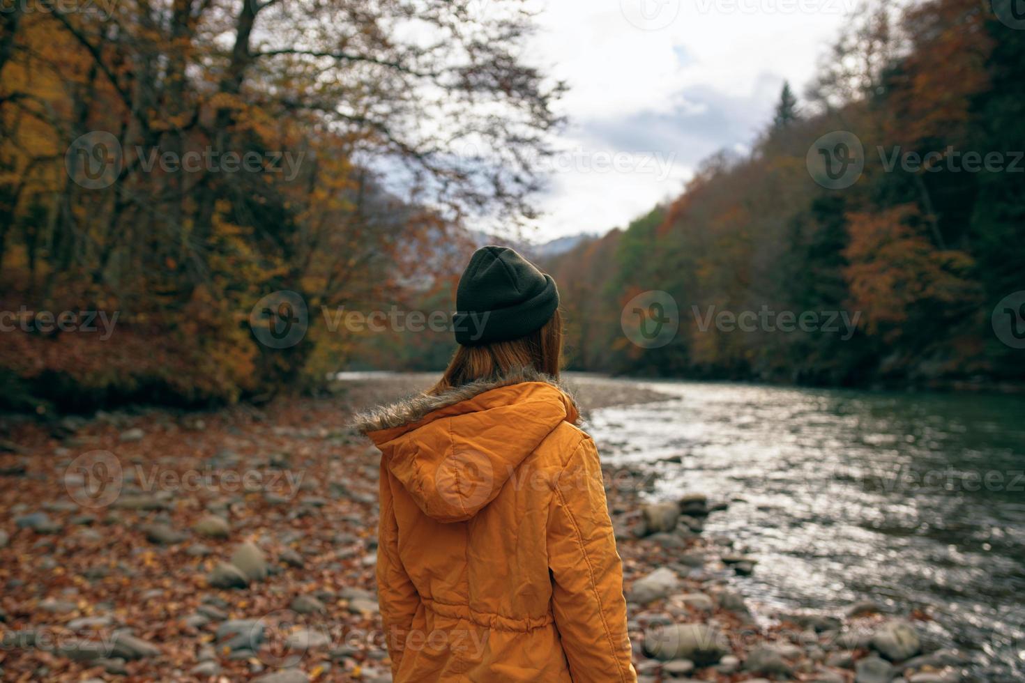 vrouw wandelen langs de rivier- gedaald bladeren herfst reizen foto