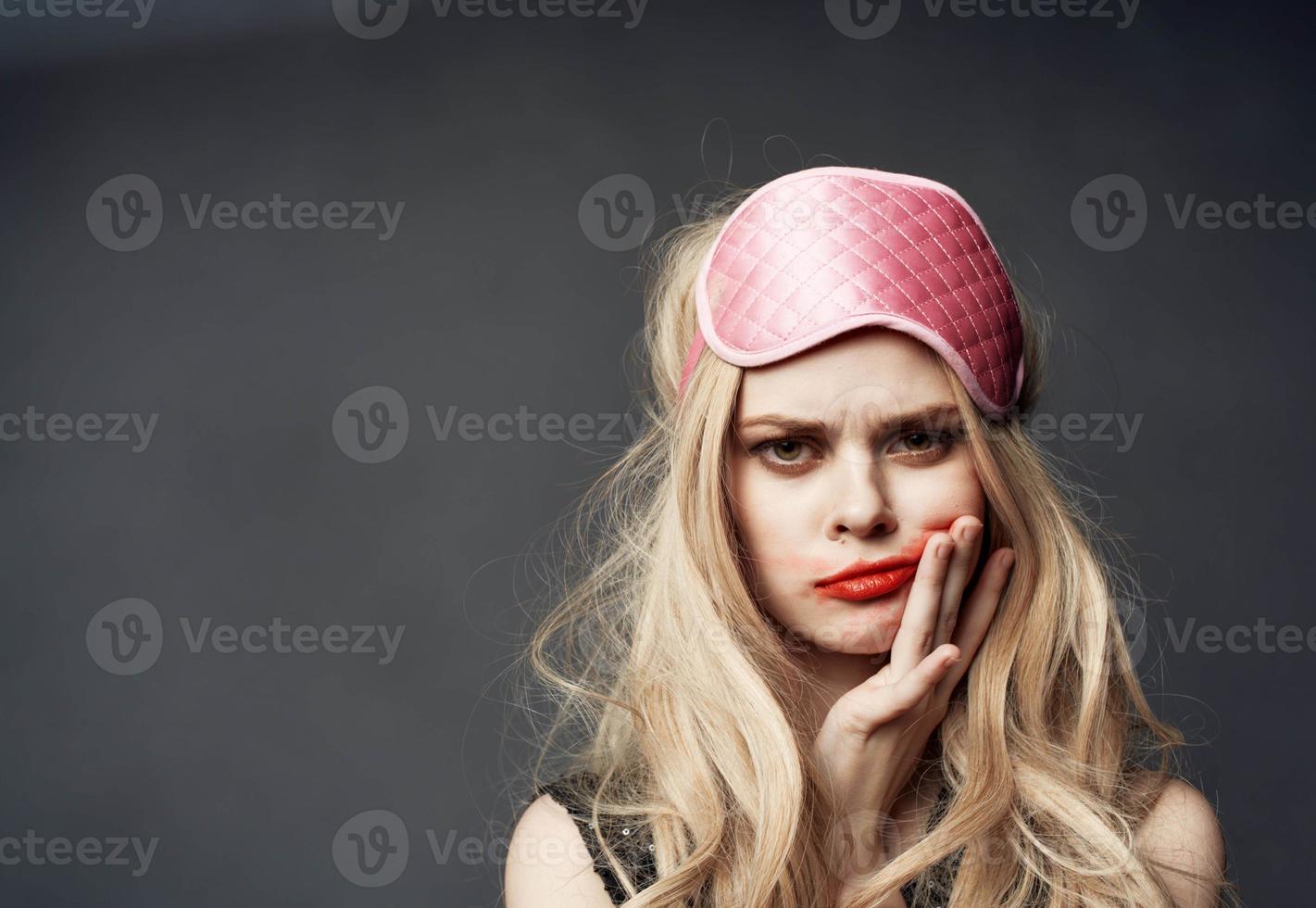 vrouw met roze masker Aan haar hoofd besmeurd rood lippenstift allemaal over- haar gezicht foto