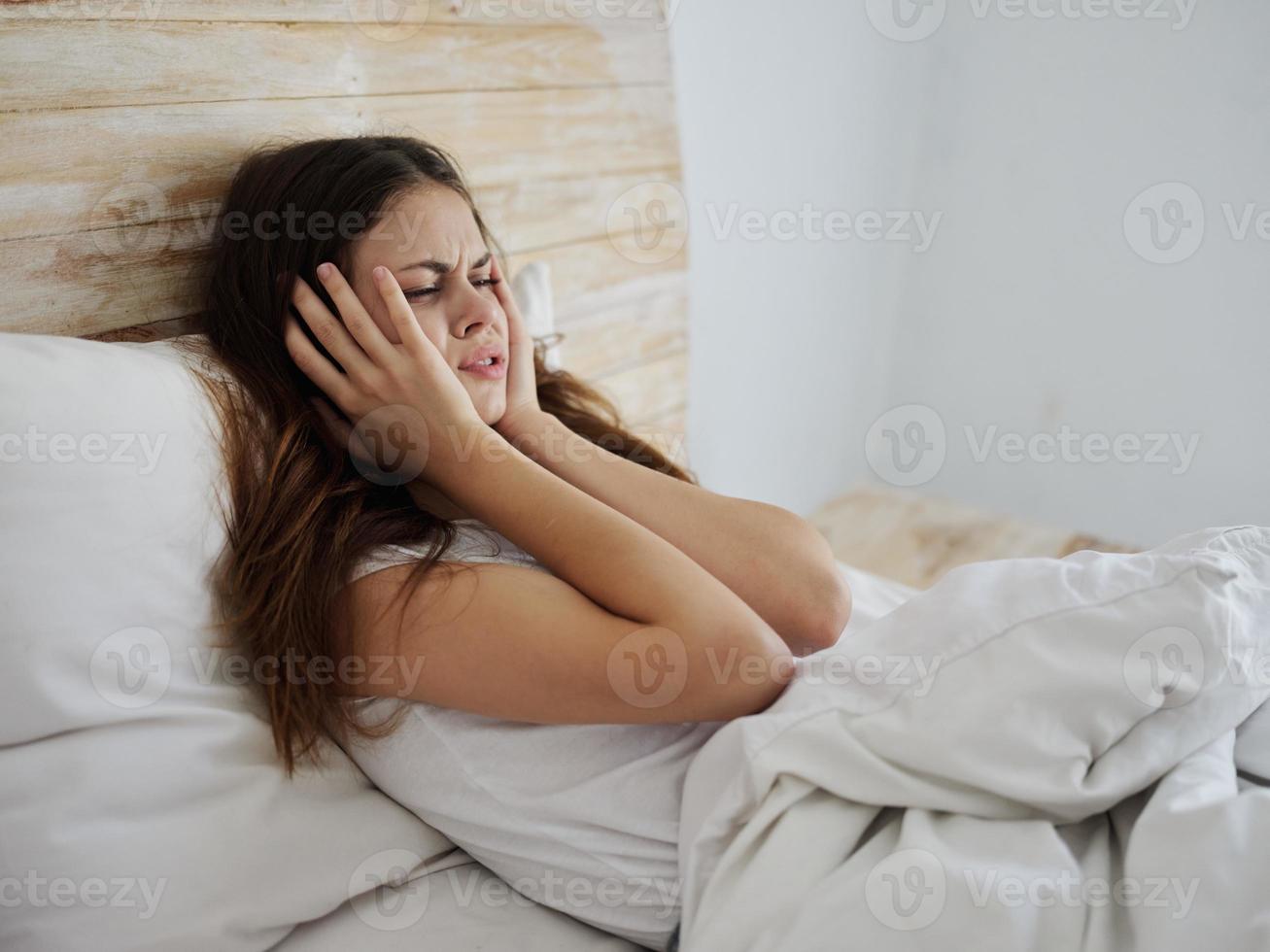 vrouw Holding handen in de buurt gezicht huilen aan het liegen bed foto