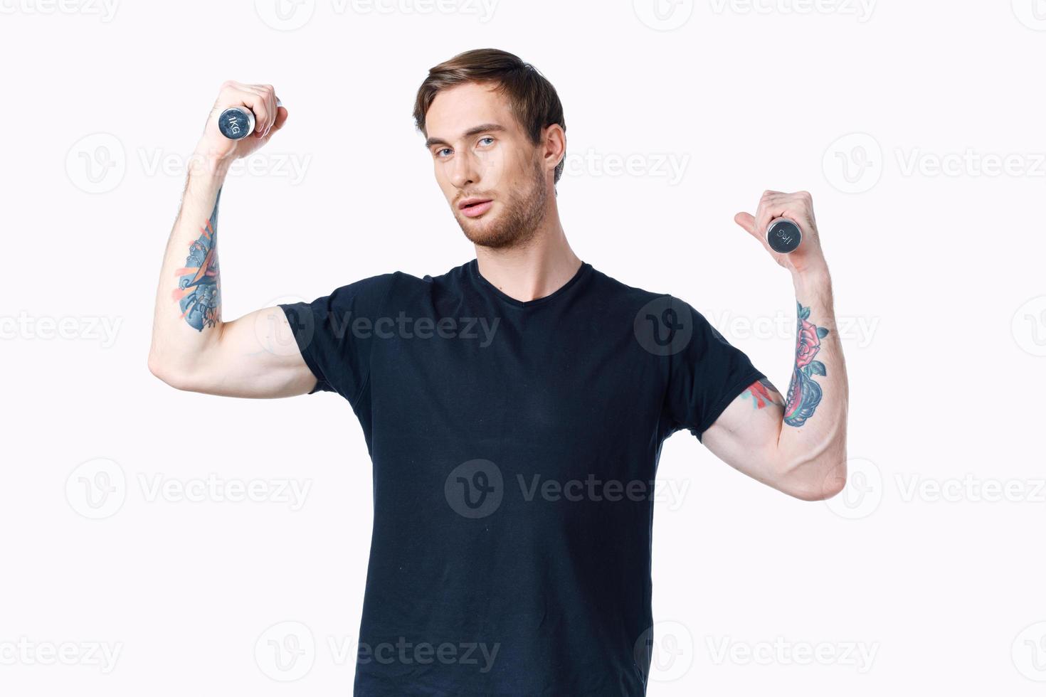Mens met halters spieren spieren bodybuilder geschiktheid en tatoeëren Aan zijn arm foto