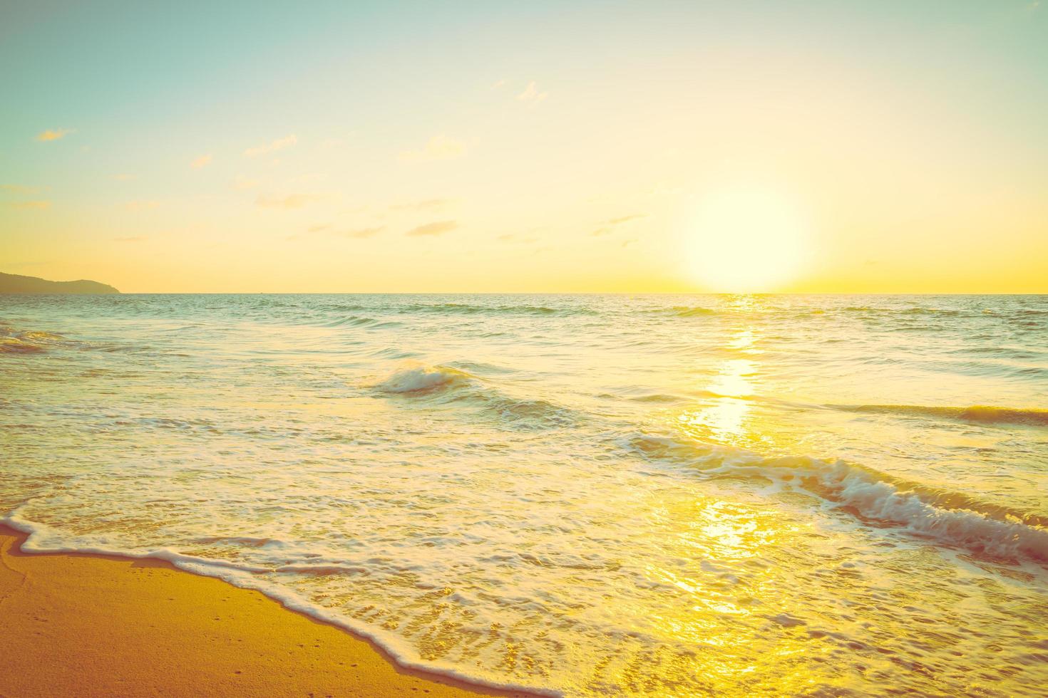 zonsondergang met zee en strand foto