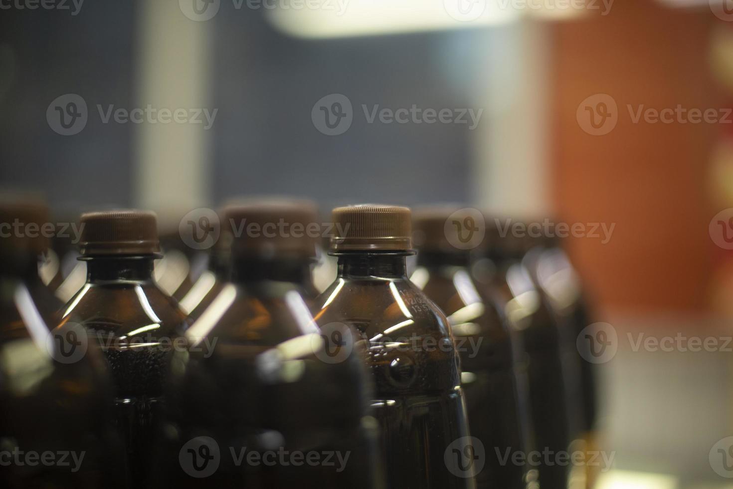 flessen van koolzuurhoudend drinken in supermarkt. water in voorraad. plastic flessen staan in rij. foto