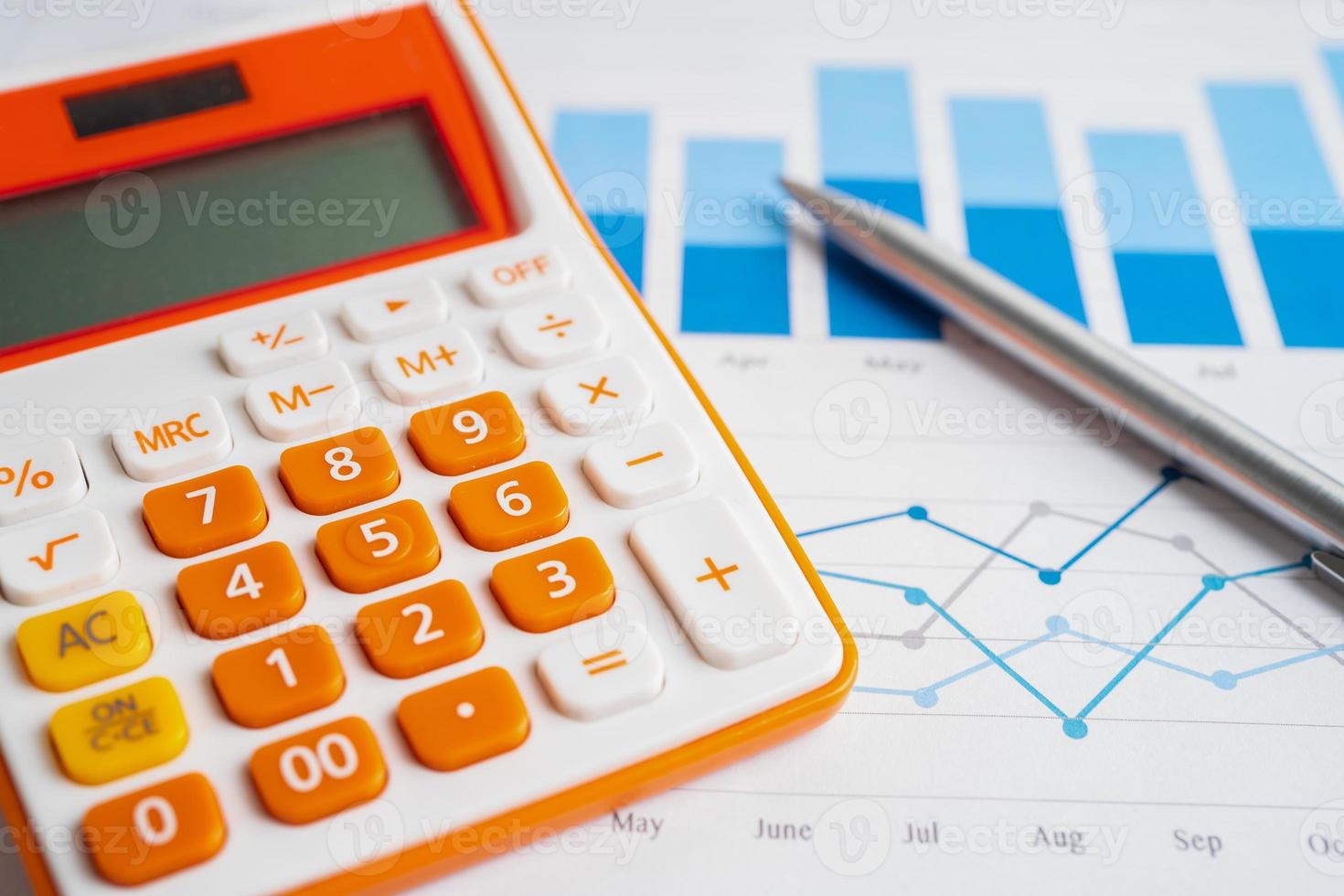 pen en rekenmachine op grafiek of ruitjespapier. financieel, account, statistieken en bedrijfsgegevensconcept. foto